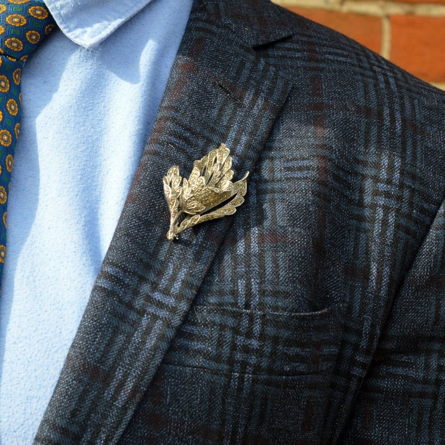 1940s chrome and marcasite floral brooch worn on a stylish blazer with a patterned tie.