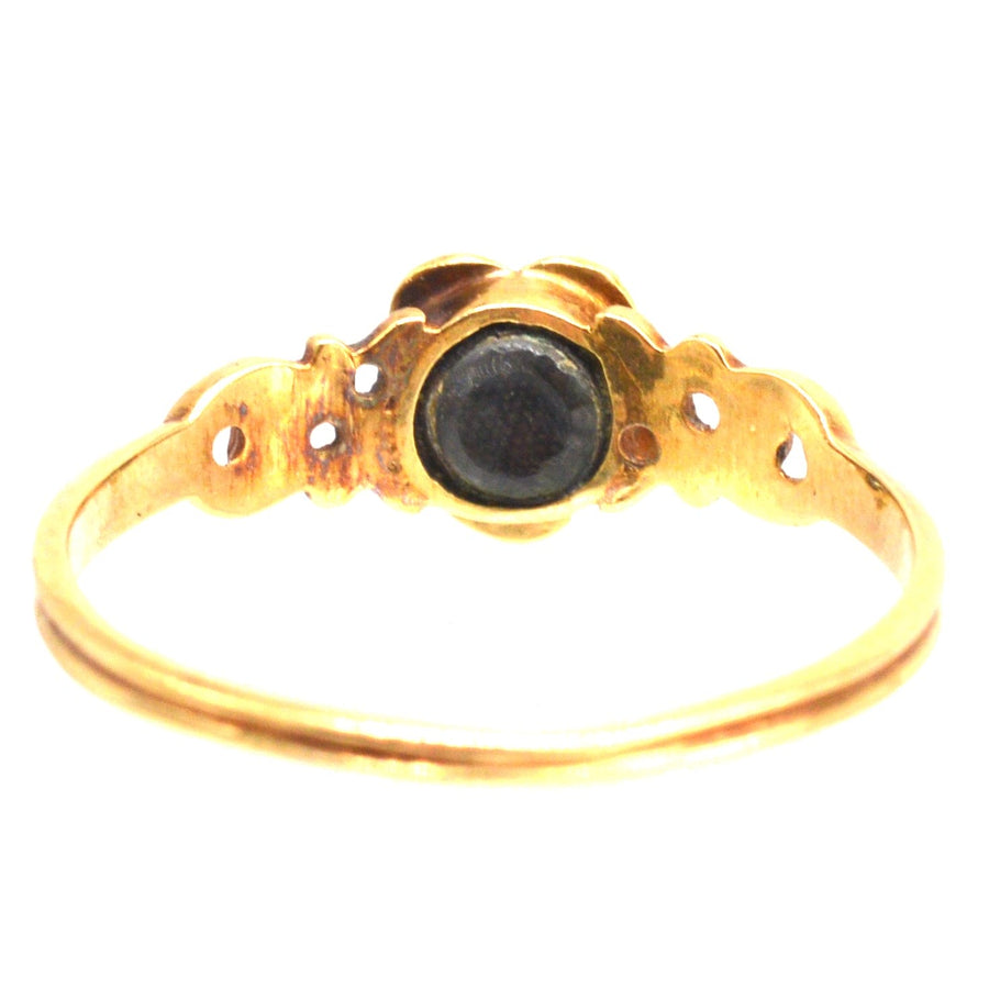 Georgian William IV 18ct gold ring featuring a central stone with a delicate floral design.