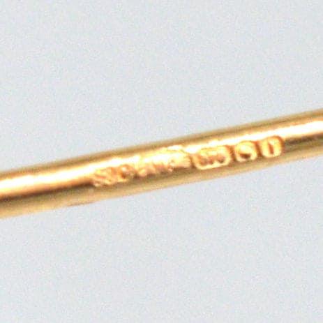Close-up of hallmark on 1940s 9ct gold earrings, showcasing authenticity and quality.