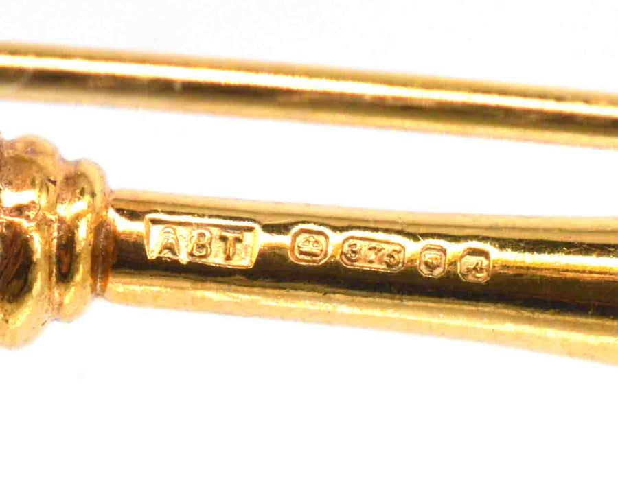 Close-up of the hallmark and inscription on a Vintage 9ct Gold Royal Mace Brooch, featuring ABT and purity marks.