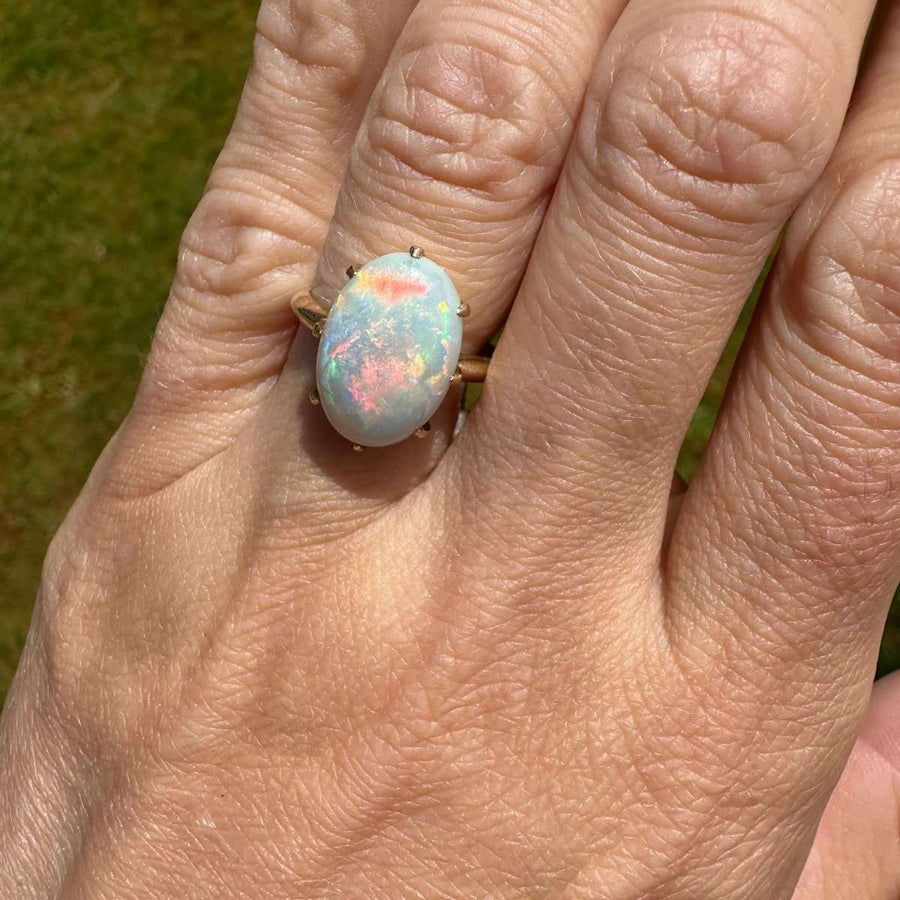 Art Deco 18ct gold ring featuring a stunning white opal with vibrant red, green, and blue color flashes.
