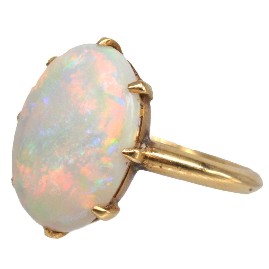 Art Deco 18ct gold ring featuring a stunning white opal with vivid red and colorful flashes.