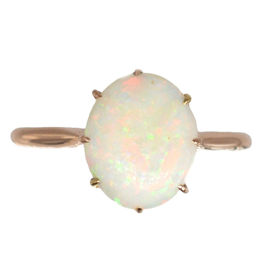 Art Deco 18ct gold ring featuring an oval natural white opal with vibrant color play.