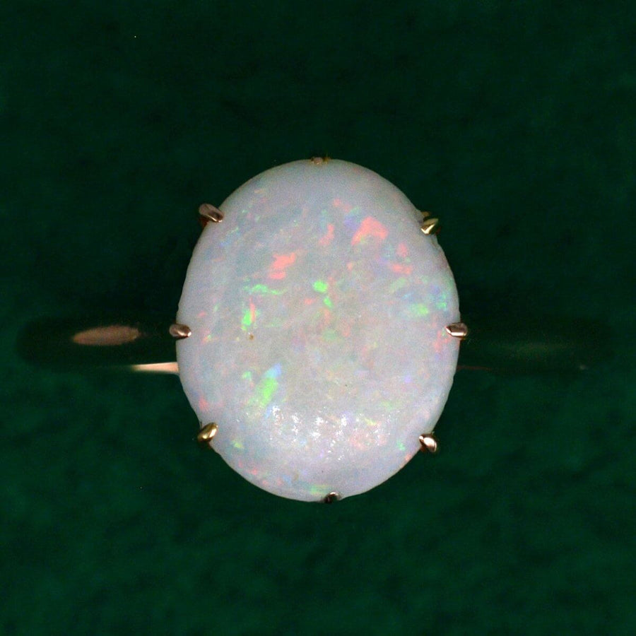 Art Deco 18ct gold ring featuring a large natural opal with vibrant red, green, blue, and yellow flecks.