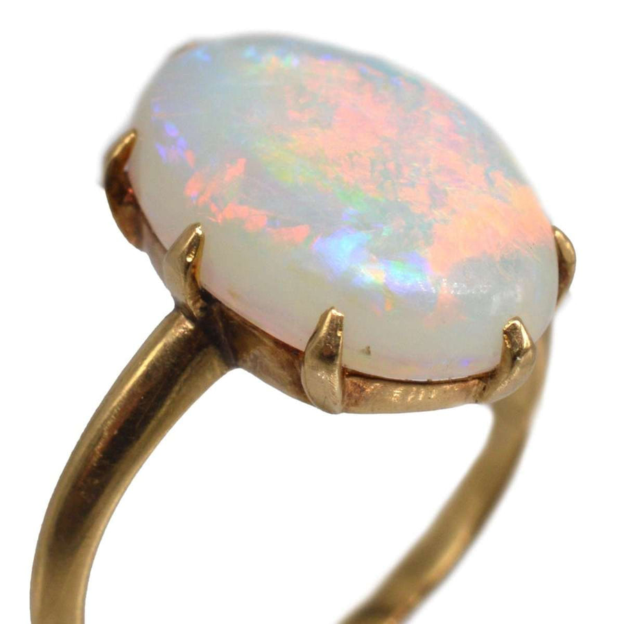 Art Deco 18ct gold ring featuring a stunning white opal with vivid red and colorful flashes.