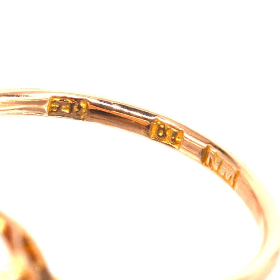 Close-up of the hallmark on an Art Deco 18ct gold opal ring, showcasing intricate gold stamps.