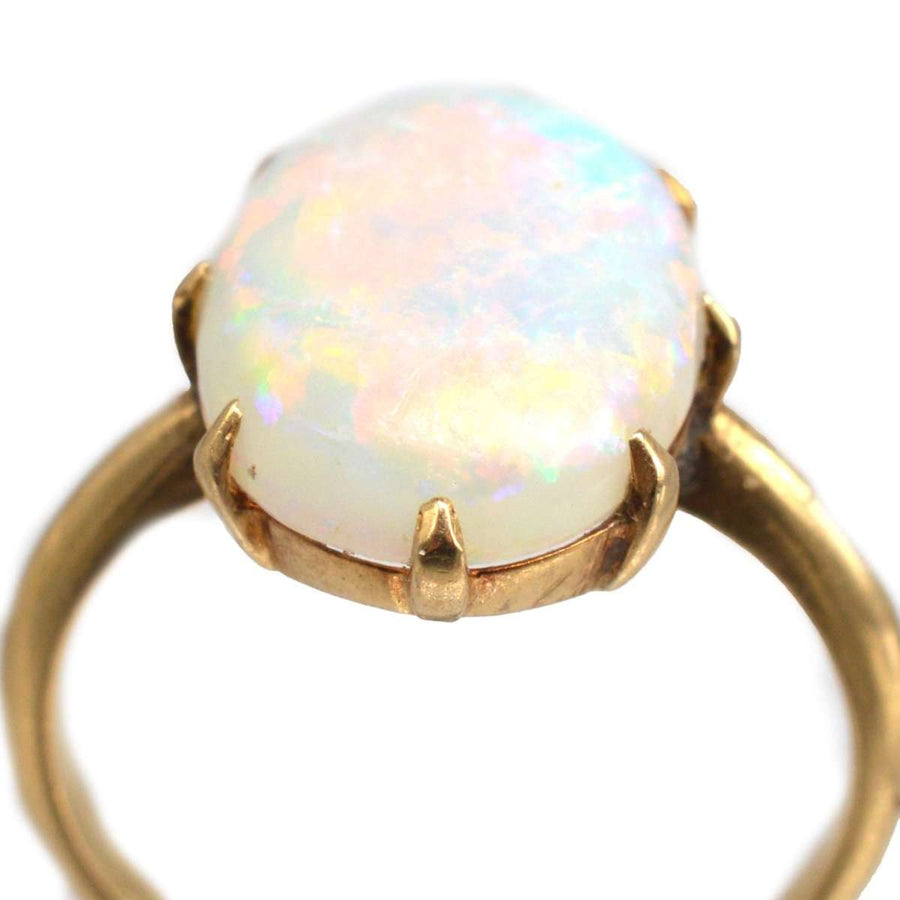 Art Deco 18ct gold ring featuring a vibrant white opal with colorful flashes of red, green, and blue.
