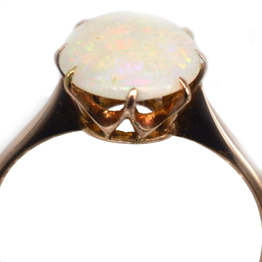 Art Deco 18ct gold ring featuring a stunning natural white opal with vibrant color play.
