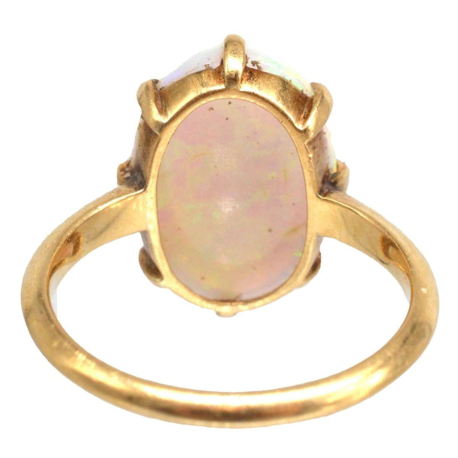 Art Deco 18ct gold ring featuring a stunning white opal with vibrant red and kaleidoscopic colors.