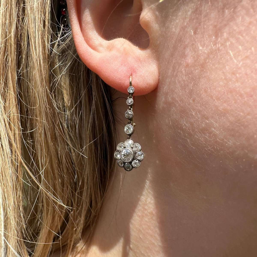 Elegant Edwardian 18ct gold and platinum diamond cluster drop earrings worn in ear.