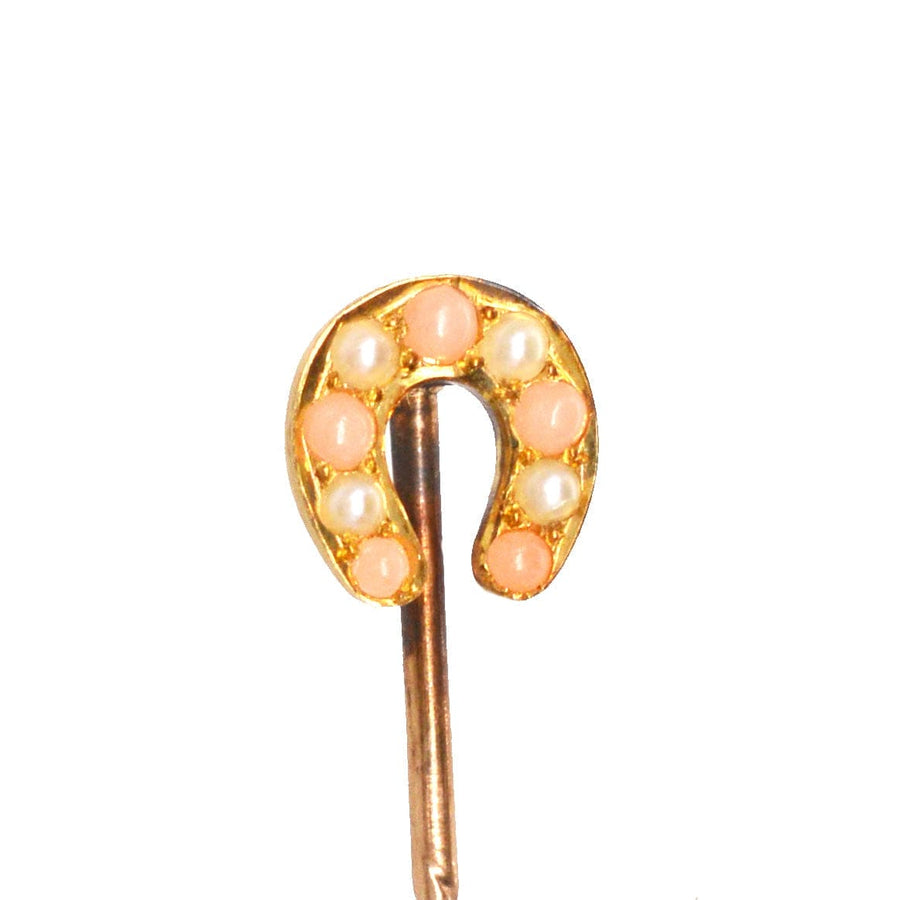 Edwardian 9ct gold horseshoe tie pin with pearl and angel skin coral accents, a symbol of good luck.