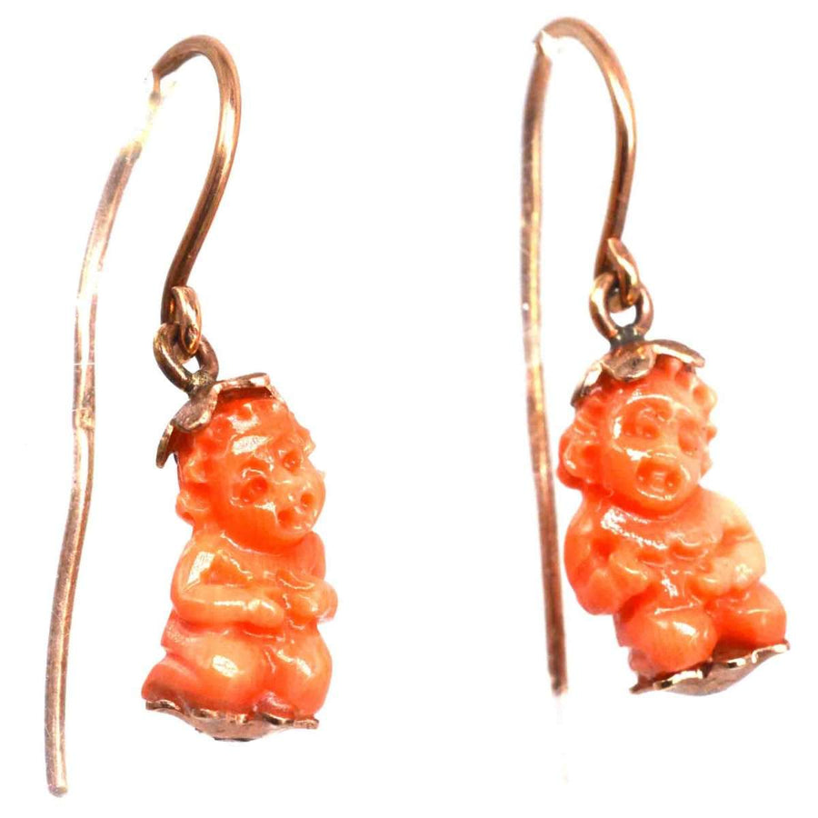 Georgian 12ct gold coral Cupid earrings featuring carved coral cupids, symbolizing love and protection.