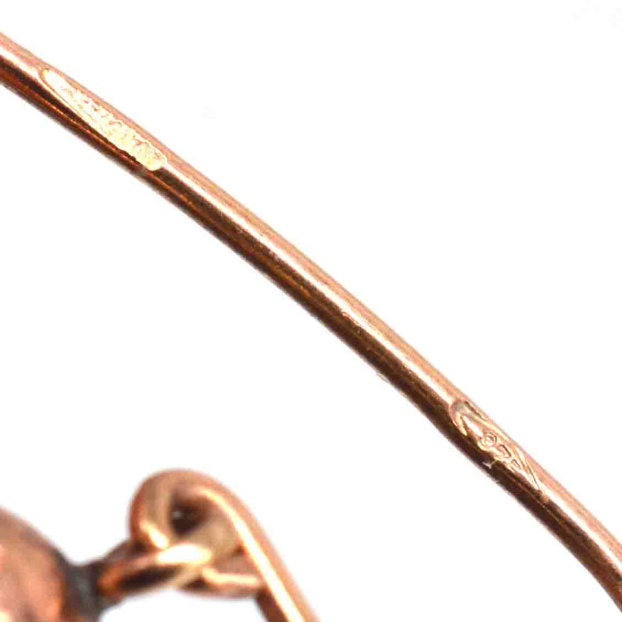 Close-up of Georgian gold coral Cupid earrings showing detailed hallmark and craftsmanship.