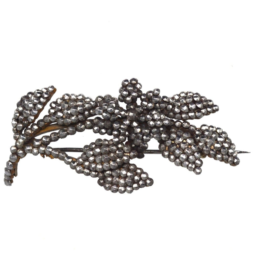 Georgian cut steel floral brooch featuring intricate design and sparkling riveted steel studs.