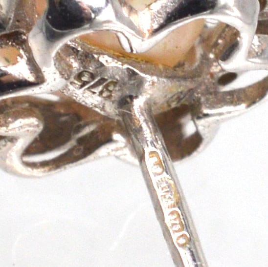 Close-up view of vintage 9ct white gold star cluster earring showing pearl and diamond details.