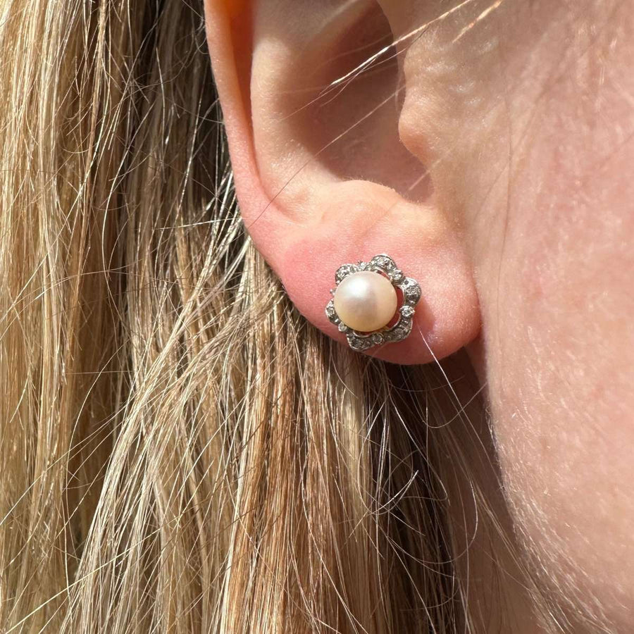 Mid-century 9ct white gold pearl and diamond star cluster earrings worn on the ear, showcasing elegance and vintage charm.