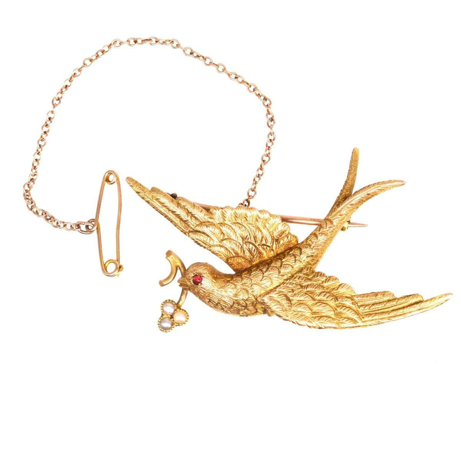 Victorian 15ct gold swallow bird brooch with seed pearl flower, showcasing intricate filigree and vintage charm.