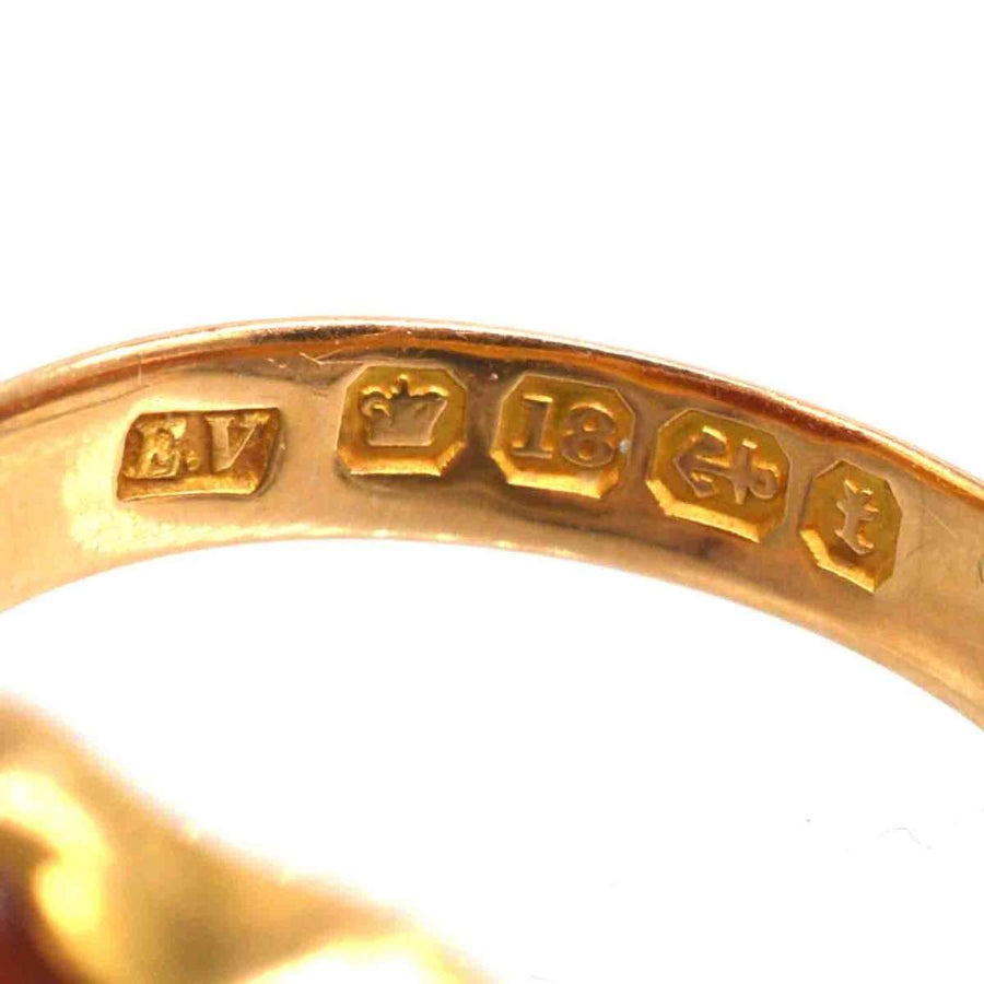 Close-up of hallmarks on a Victorian 18ct gold signet ring, showcasing detailed engravings for authenticity.