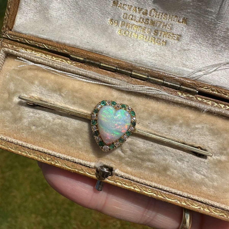 Victorian 18ct gold bar brooch featuring a heart-shaped opal surrounded by emeralds and diamonds in a fitted box.