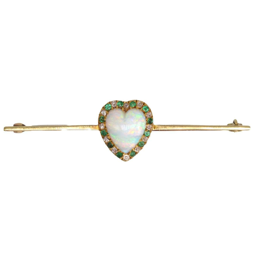 Victorian 18ct gold bar brooch featuring heart-shaped opal, surrounded by diamonds and emeralds.