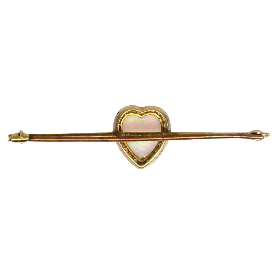 Victorian 18ct gold bar brooch featuring a heart-shaped opal, surrounded by diamonds and emeralds.