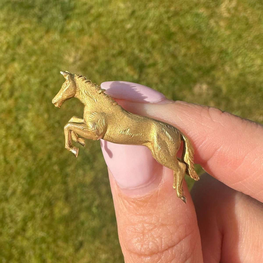Vintage 9ct gold horse brooch by Alabaster & Wilson, showcasing a dynamic horse mid-jump, capturing equestrian elegance.