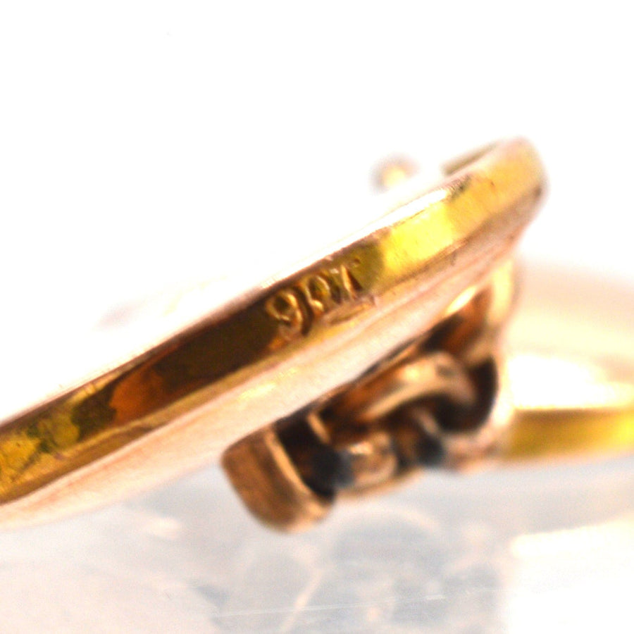Close-up of 9ct gold cufflink showing detailed hallmark and craftsmanship.