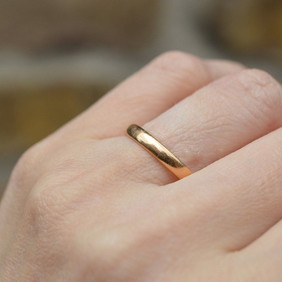 Close-up of a 1932 Art Deco 22ct gold wedding band ring on a hand, showcasing its smooth finish and comfort.