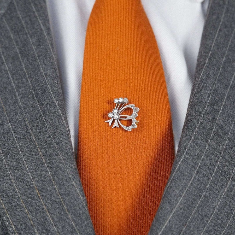 1940s 18ct white gold diamond bow brooch on an orange tie, showcasing vintage elegance and style.