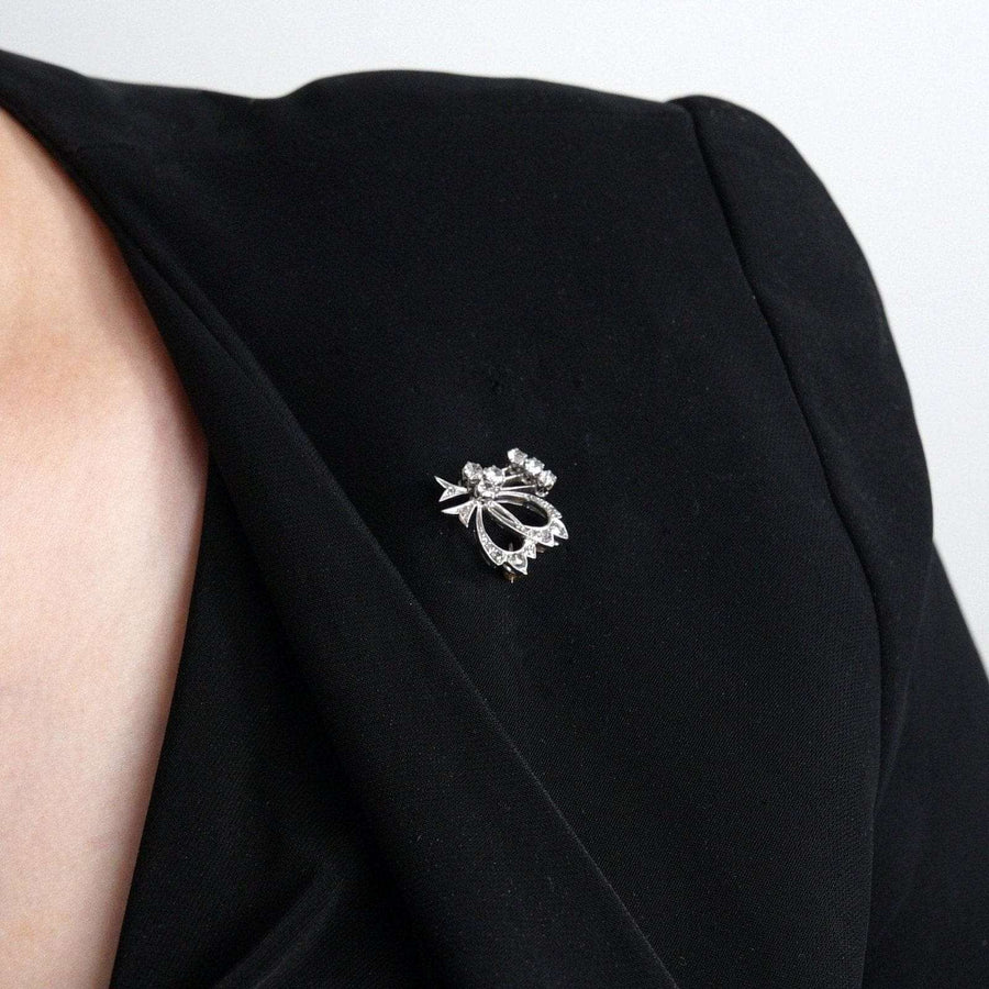 1940s 18ct white gold diamond bow brooch on a black blazer lapel, showcasing elegance and vintage charm.