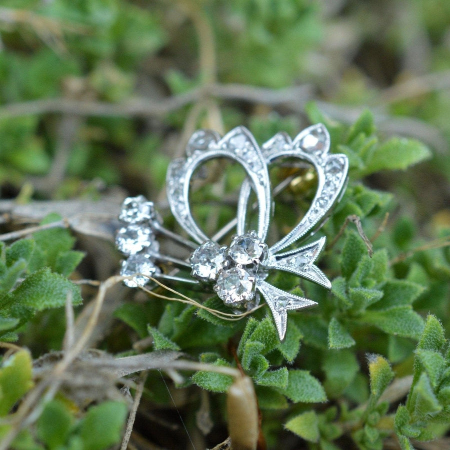 1940s 18ct white gold diamond bow motif brooch with sparkling old cuts and rose cuts in a floral setting.