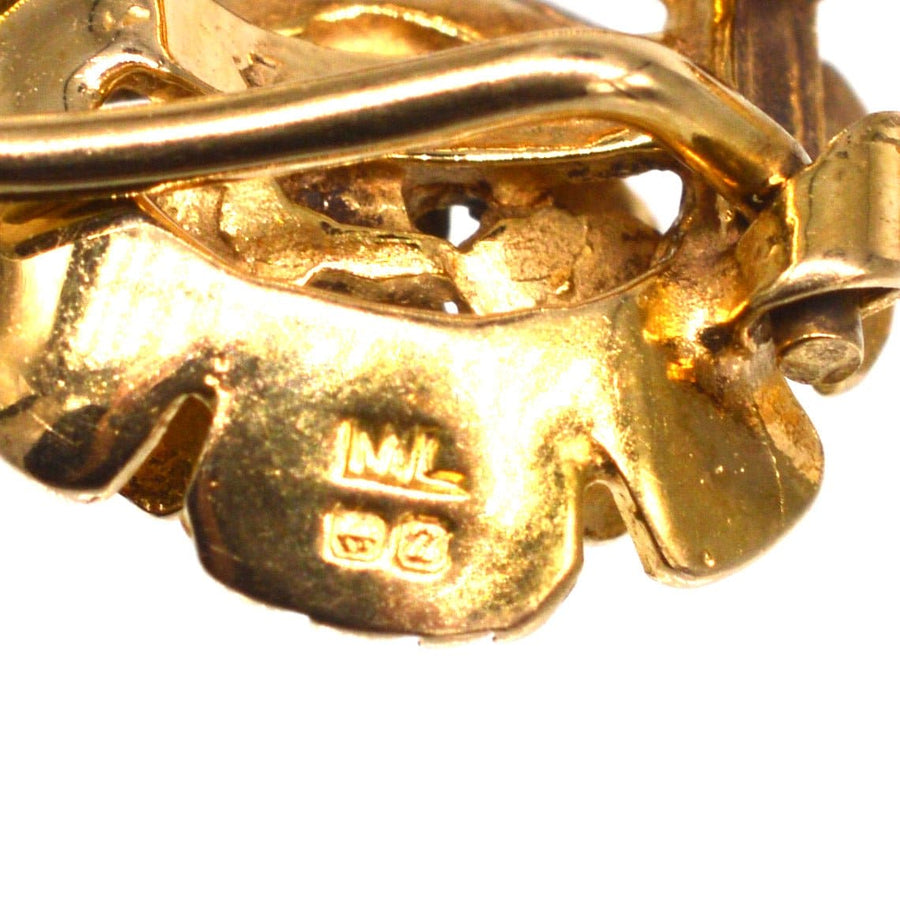 Close-up of hallmarks on 1940s 9ct gold flower clip on earrings, showcasing intricate detailing and craftsmanship.