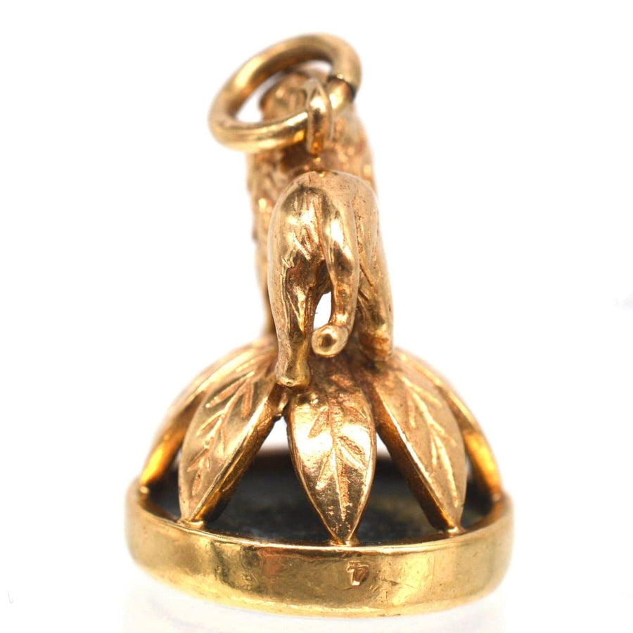 1940's 9ct gold lion pendant with wreath base and bloodstone seal, showcasing intricate craftsmanship.