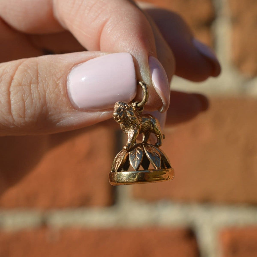 1940's 9ct gold pendant featuring a lion on a wreath with a bloodstone seal, showcasing intricate craftsmanship.
