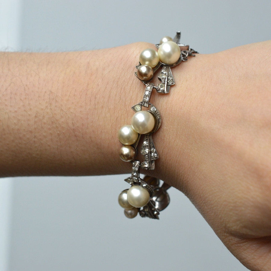1940s retro sterling silver bracelet featuring faux pearls and white paste diamonds on a wrist.