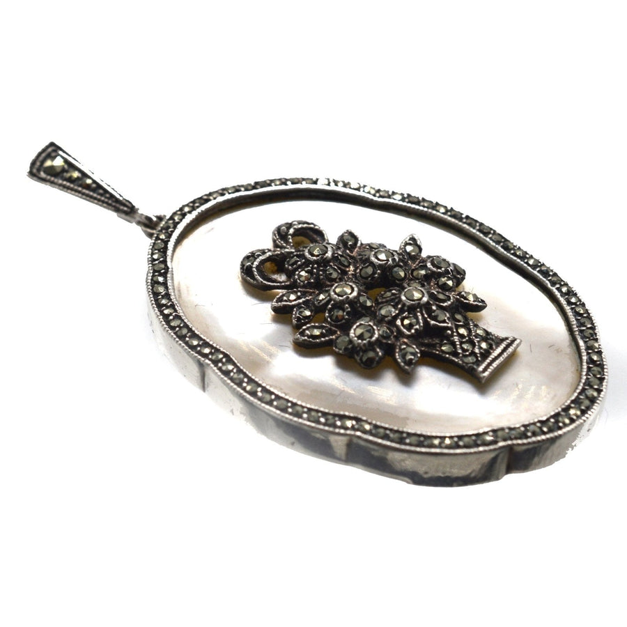1940s silver pendant featuring mother of pearl and marcasite, designed as a basket of flowers, elegant vintage jewelry.