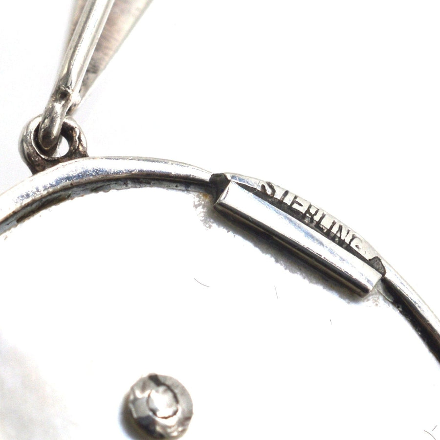 Close-up of the 1940s silver pendant showing the 'Sterling' mark, highlighting its quality craftsmanship.