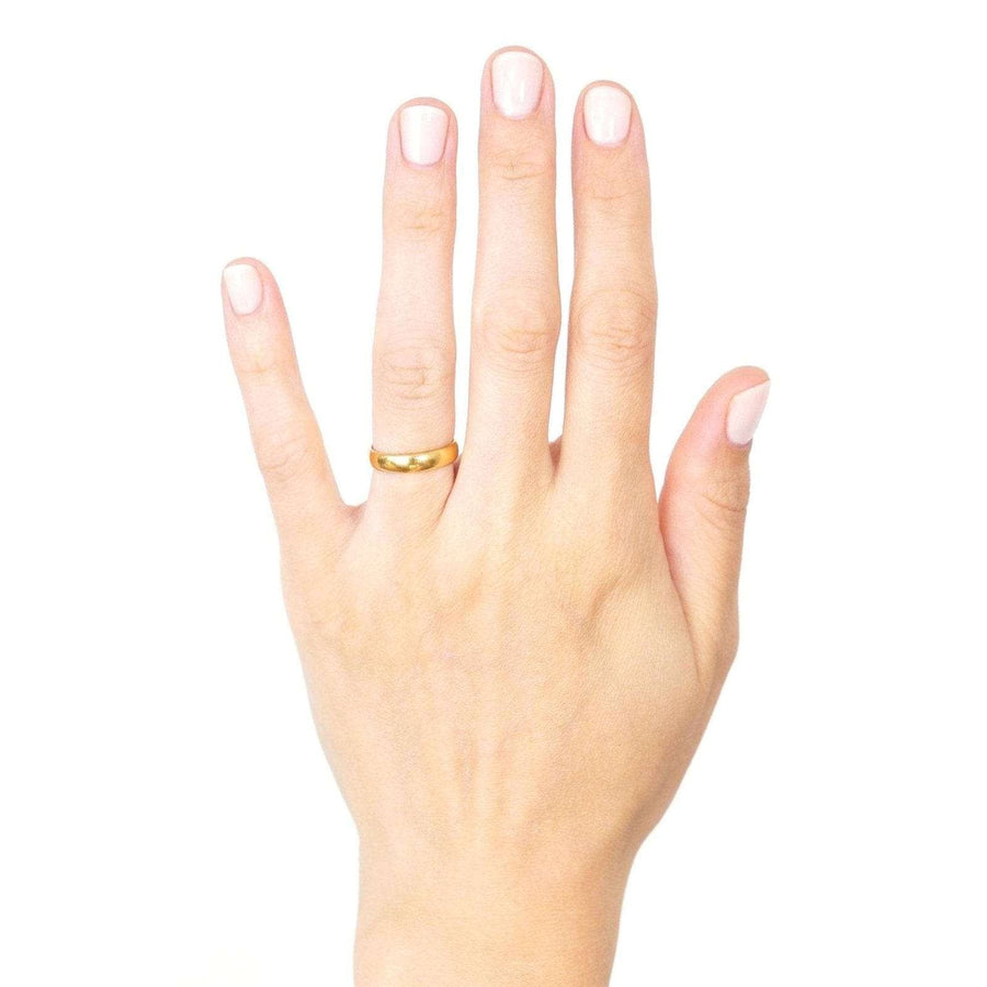 1950s 22ct gold wedding ring displayed on hand, showcasing its buttery gold color and classic design.