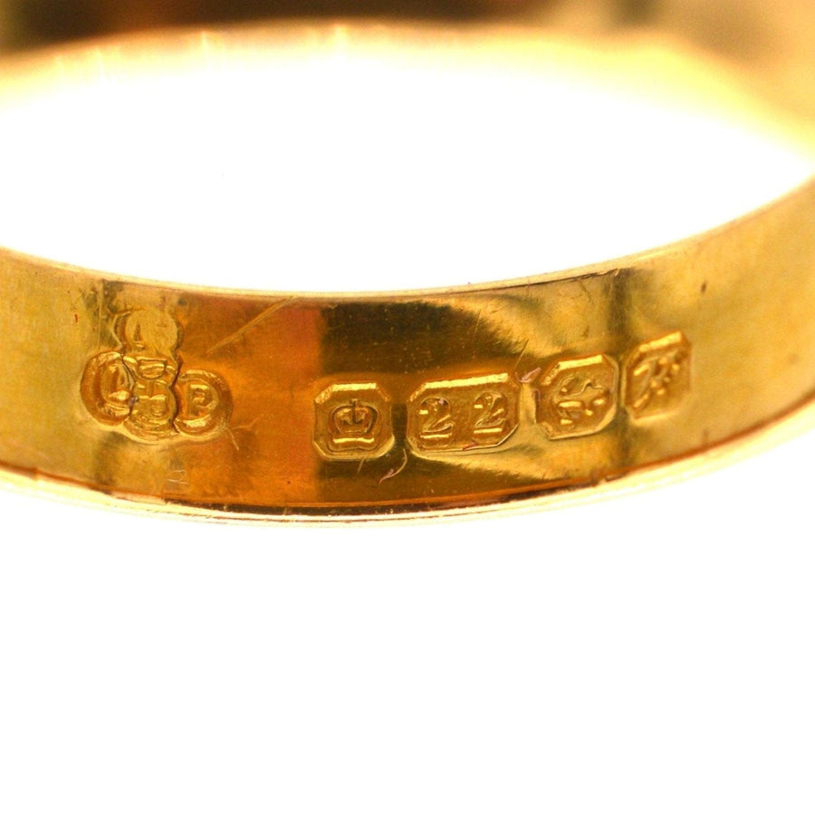 Close-up of 1950s 22ct gold wedding ring hallmark, showcasing the Birmingham maker's marks and buttery gold finish.