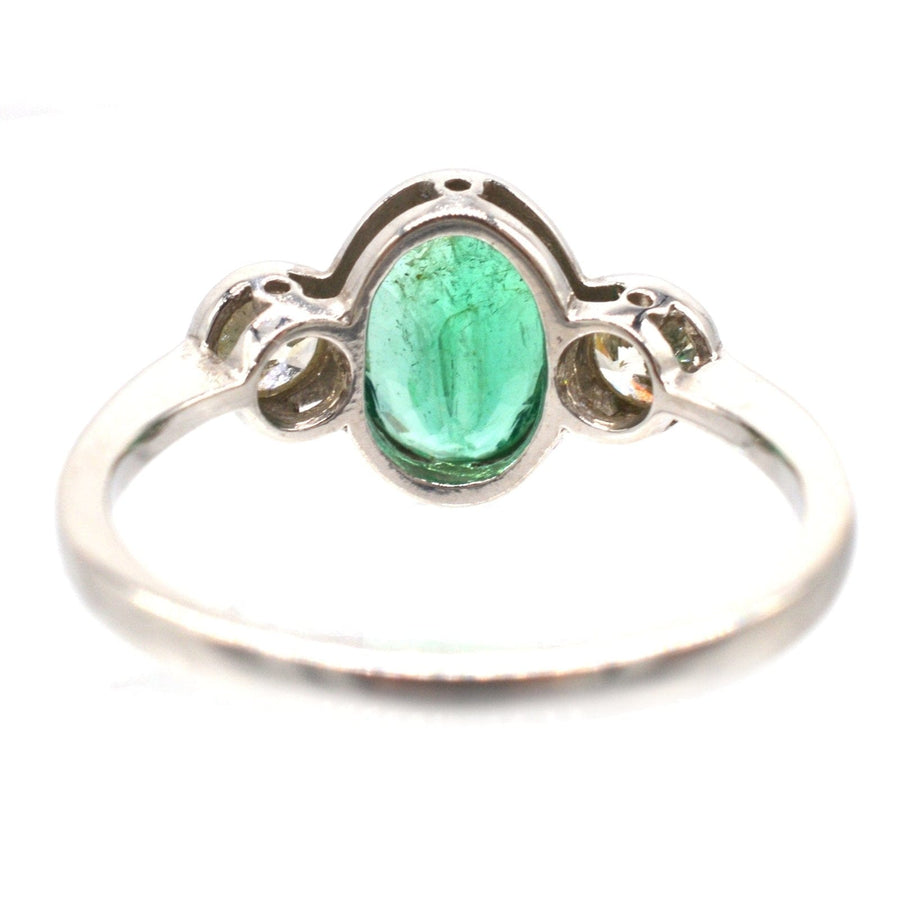 1950s platinum bezel ring featuring a 1 carat apple green emerald and sparkling diamonds, perfect for vintage engagement.