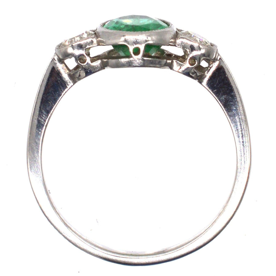 1950s platinum ring featuring a 1 carat apple green emerald and diamond accents, perfect for vintage engagement or anniversary.
