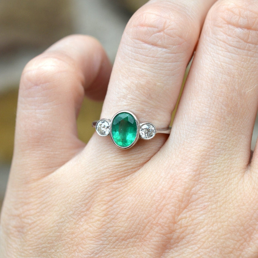 1950s platinum three stone bezel ring featuring an emerald and diamond, perfect vintage engagement or anniversary ring.