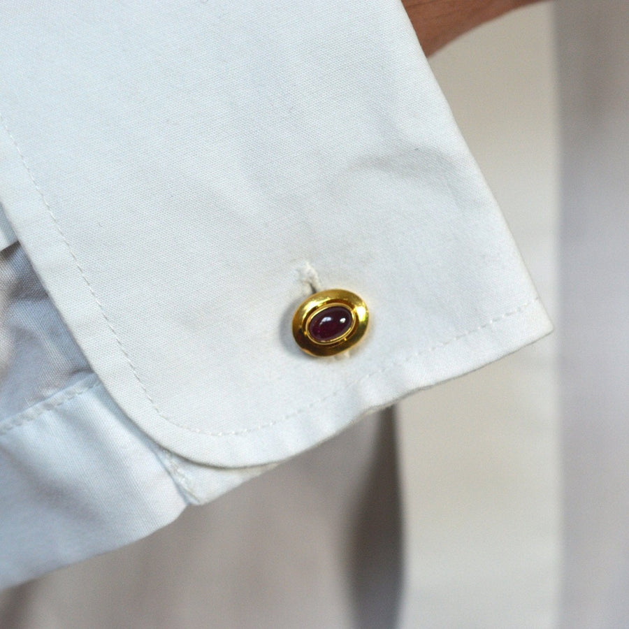 1960s 18ct gold cufflinks featuring a natural unheated cabochon ruby on a white shirt cuff.