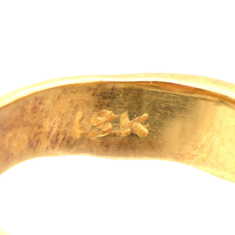 Close-up of the inner band of a 18ct gold ring, featuring the hallmark stamp.