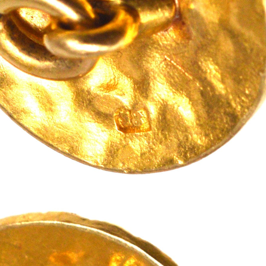 Close-up of 1960s 18ct gold cufflinks showcasing textured finish and hallmark.