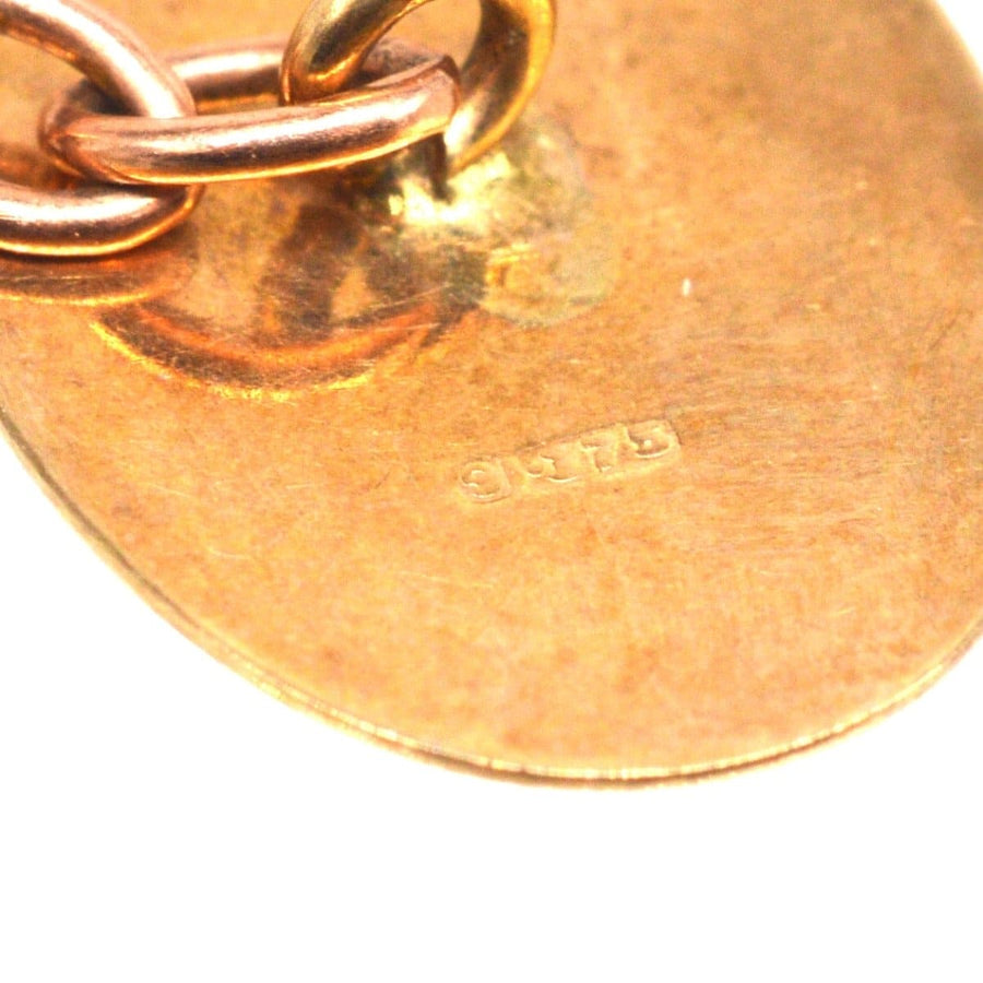 Close-up of 9ct gold cufflink showing the hallmark and chain detail, reflecting vintage craftsmanship.