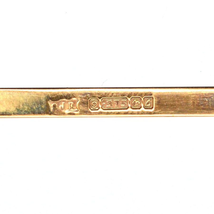 Close-up of a 1960s gold brooch hallmark, showcasing 9ct gold quality and assayer marks from Birmingham.