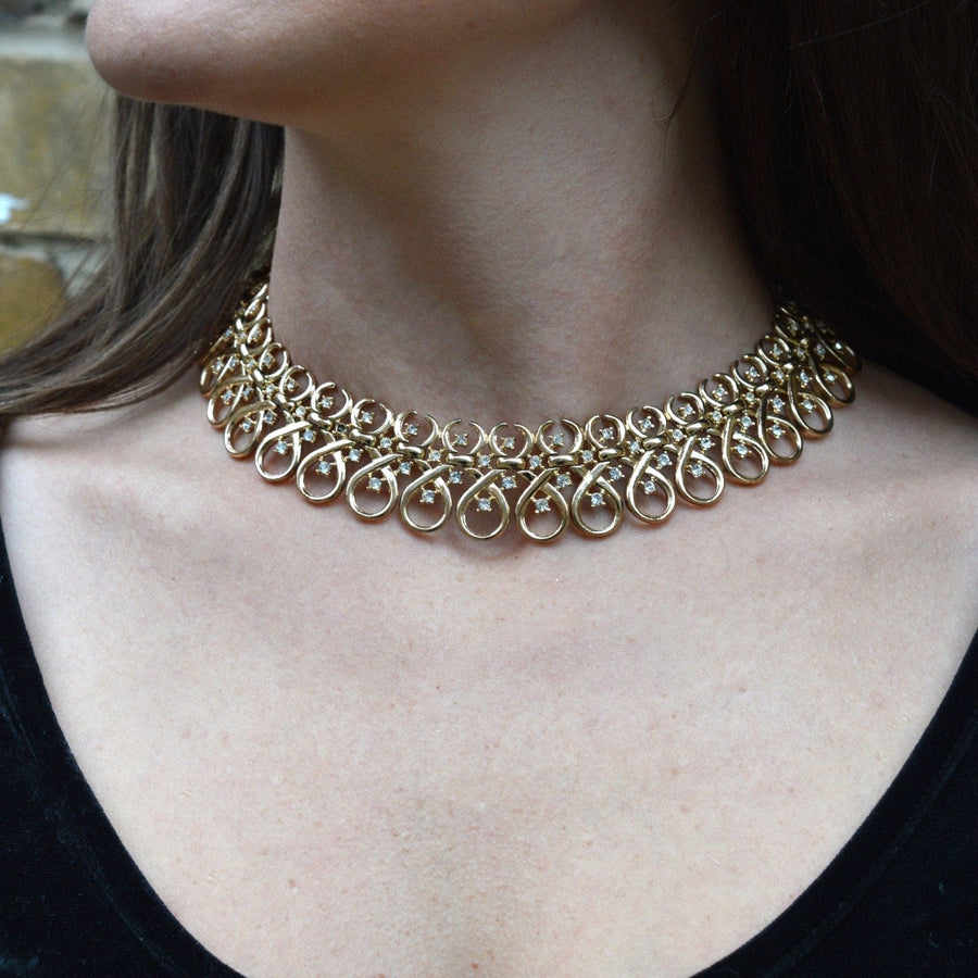 Vintage 1960s Trifari gold-tone necklace featuring interlinked swirls and diamond pastes, perfect for collectors.
