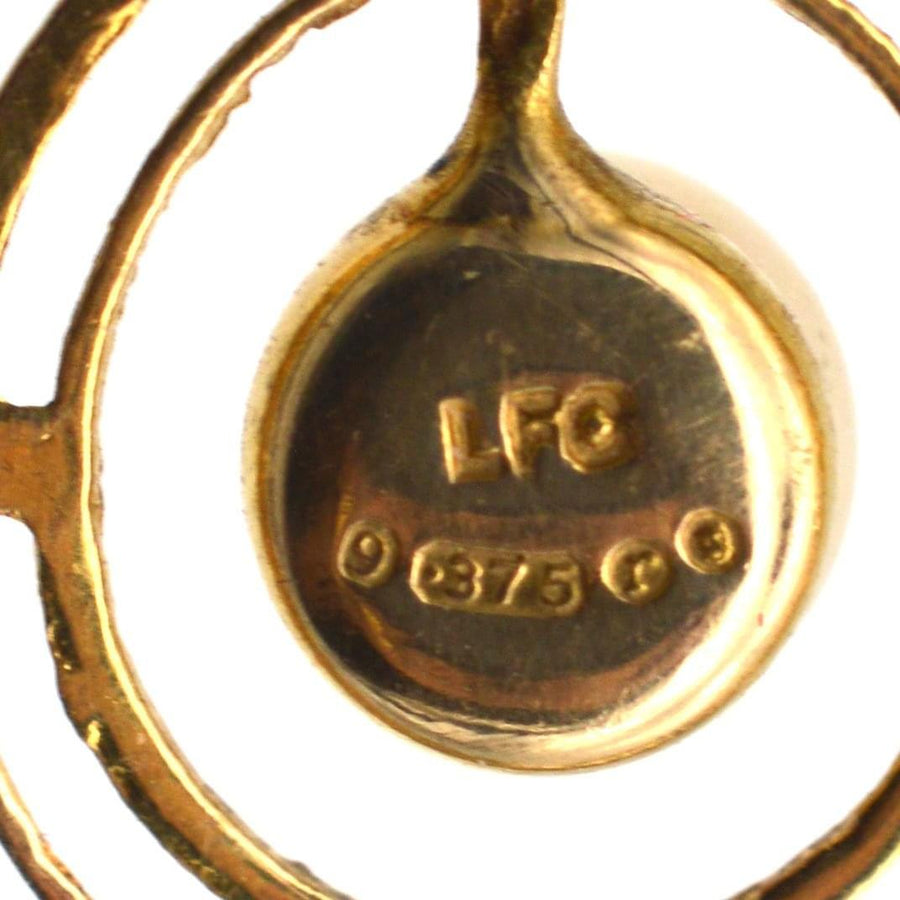 Close-up of 1970s 9ct gold pendant hallmark and purity stamp, showcasing vintage craftsmanship.