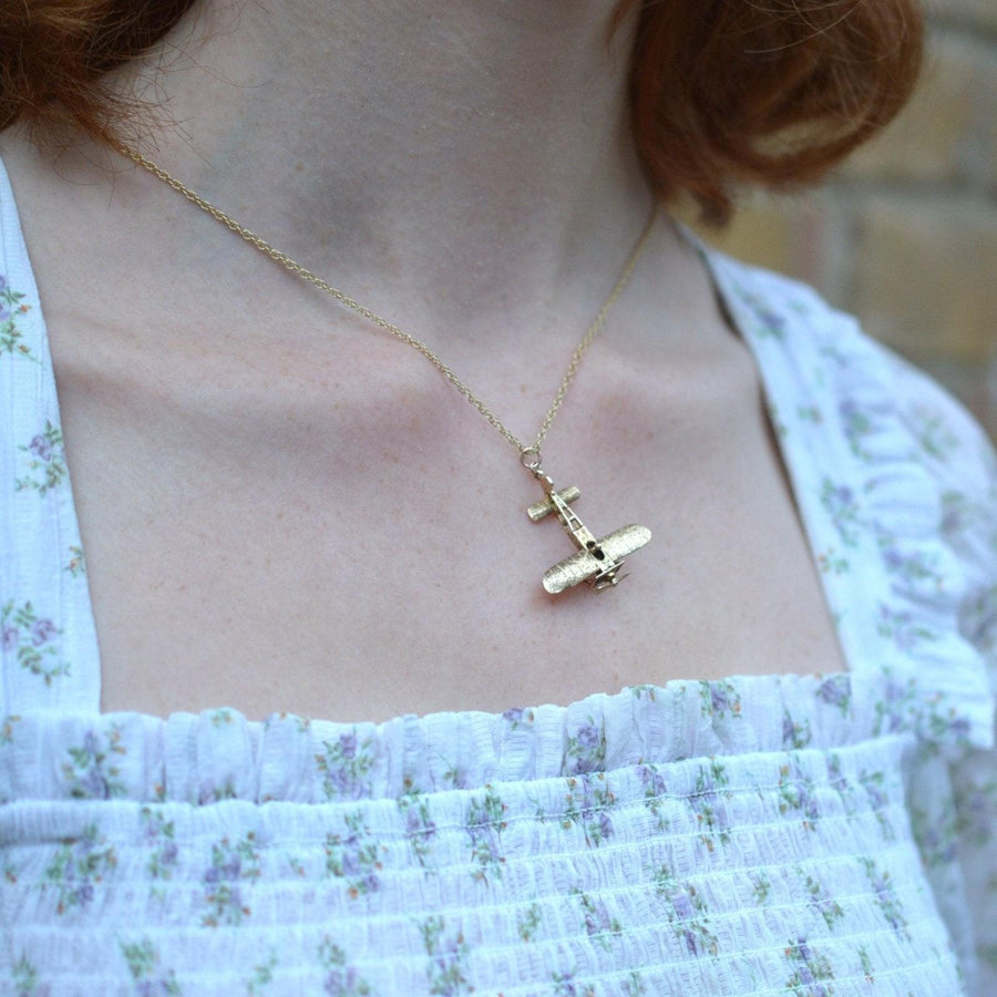 9ct gold vintage Aerolane pendant on a woman's neck, showcasing intricate design and spinning propeller.